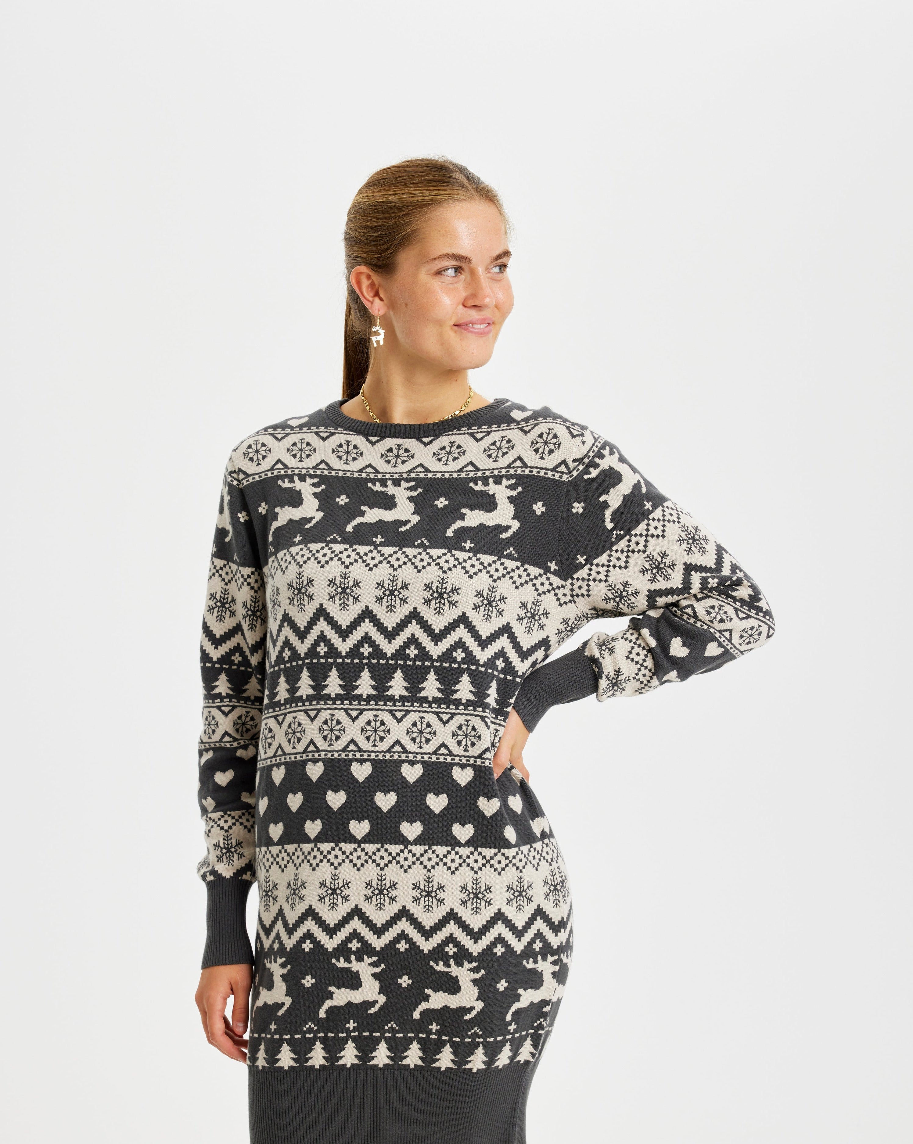 Een vrouw kijkt opzij in een grijze kerstjurk.